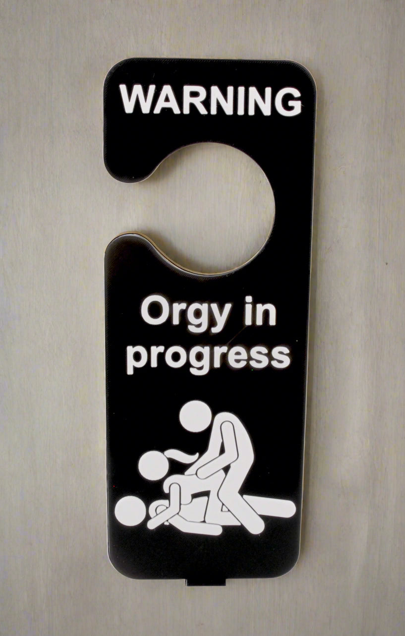 Door hanger with 'WARNING: Orgy in progress' text and graphic on a white background