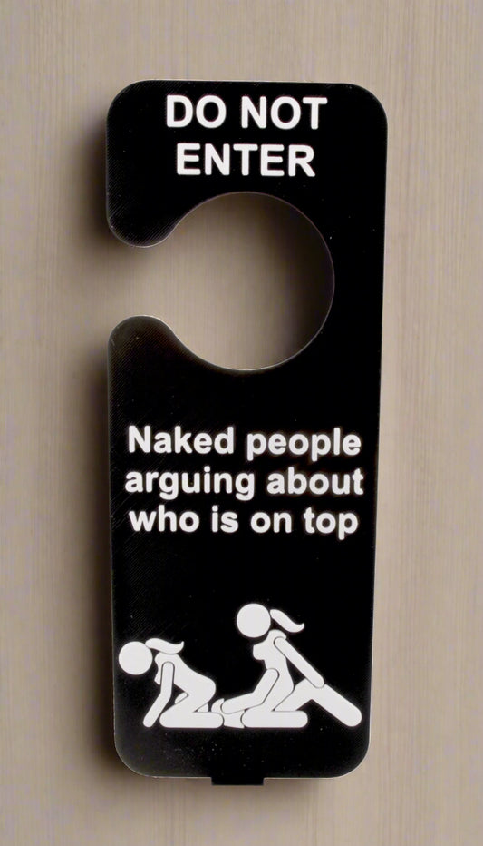 Door sign with humorous text and graphic of two people on a bed.