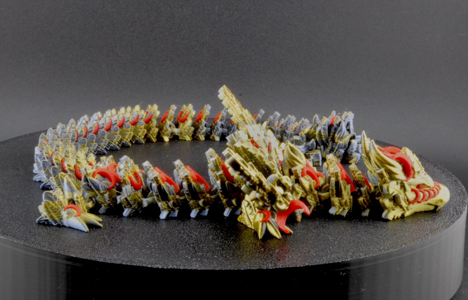 Model of a dragon-like creature on a black stand with a gray background