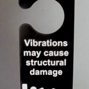 Door hanger with warning text about vibrations causing structural damage on a white background